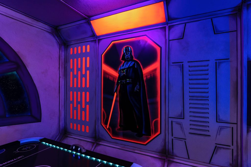 Stars Wars themed game room with custom black light reactive mural of Darth Vader