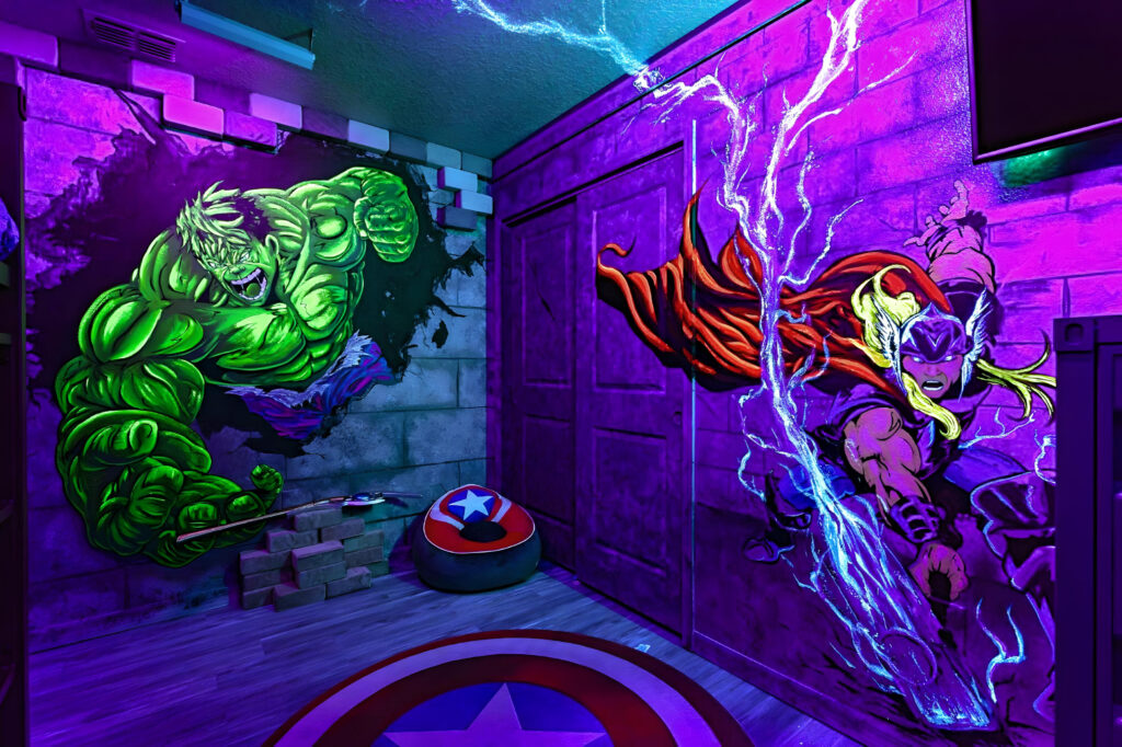 Avengers themed bedroom with black light reactive hand painted mural of Thor and Hulk in Orlando airbnb vacation home designed by Magic Interiors