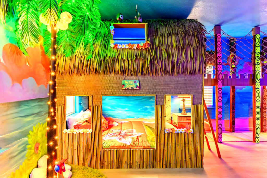Moana tiki hut bunk bed close up with walking bridge and black light reactive effects Orlando airbnb - Magic Interiors